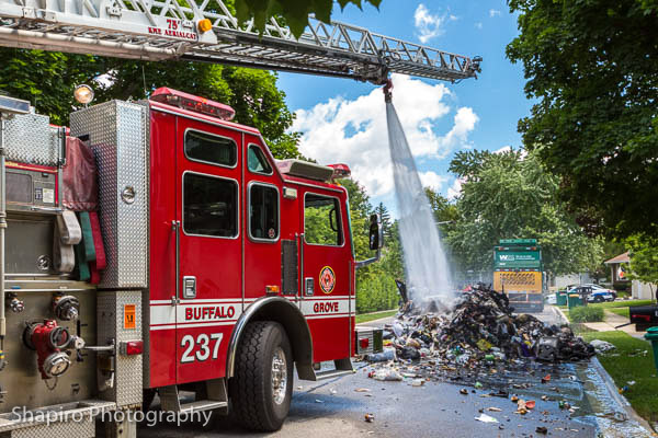 Buffalo Grove Fire Department extinguishes a trash pile burning in the street on Logsdon Avenue July 8 2014 Larry Shapiro photography shapirophotography.net